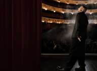 Burhan G står på scenen i en koncertsal og kigger op