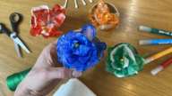 Blå papirblomst i plastikkop i café ODEON Social