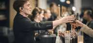 Tjener serverer drikkevarer hen over baren